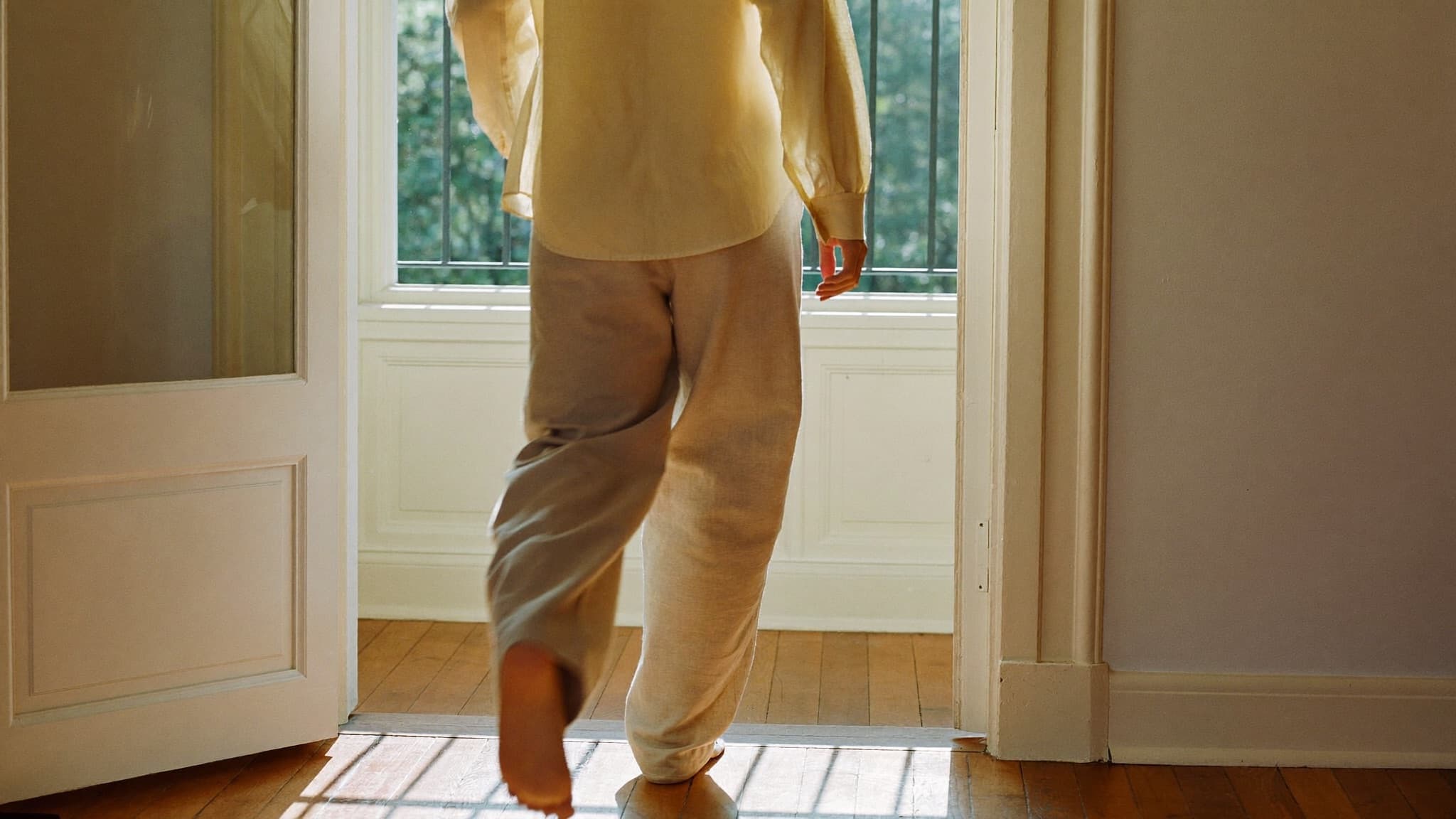 A person walking into a sunlit room \u2014 the moment a home becomes real